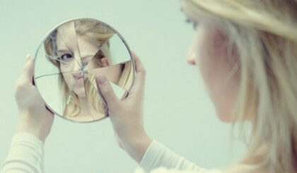 Kvinne ser i et ødelagt speil.