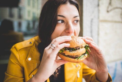 Kvinne spiser en burger