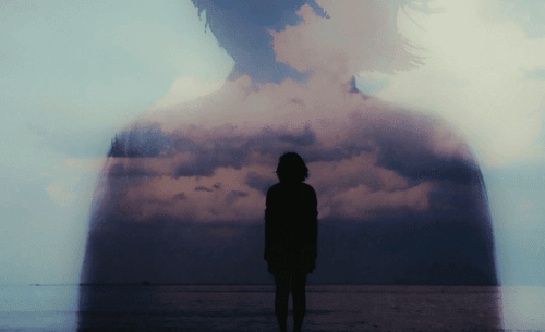Kvinne i horisonten foran sjøen.