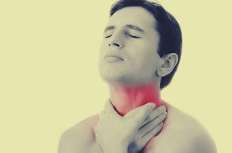 En mann berører sin smertefulle hals