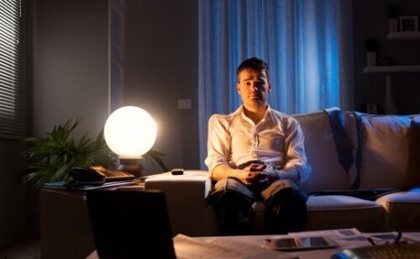 Mann med søvnløshet sitter i sofaen