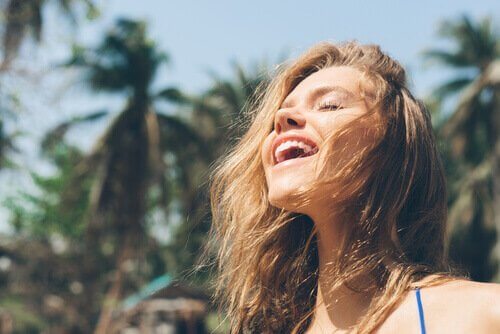 En kvinne som nyter sollyset og føler seg lykkelig