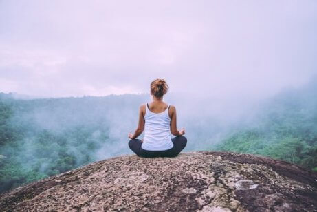 En kvinne som mediterer på et fjell