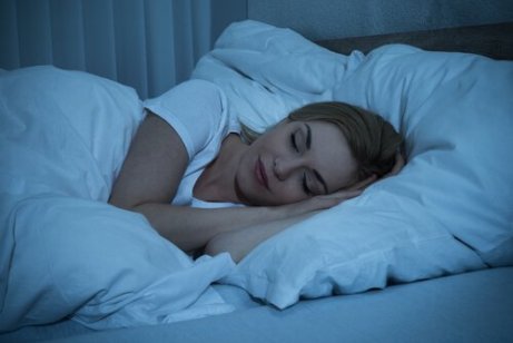 En kvinne som sover i sengen