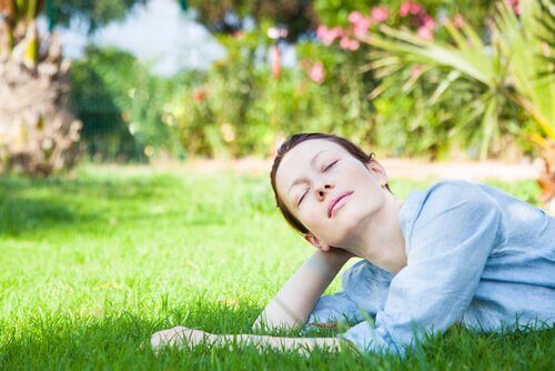 Kvinne ligger i gresset og tenker på hva hun elsker