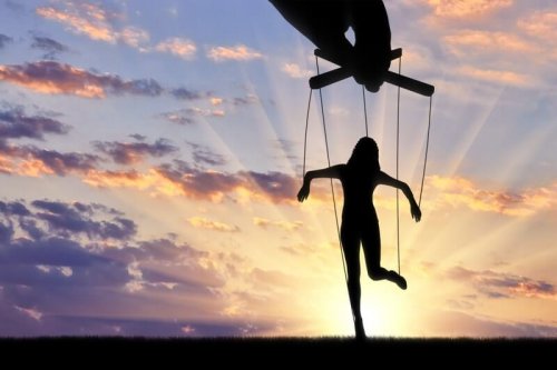 En hånd manipulerer en kvinnedukke