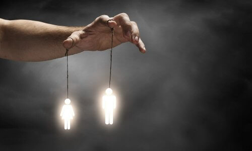 En hånd med menneskelige figurer knyttet til to fingre.