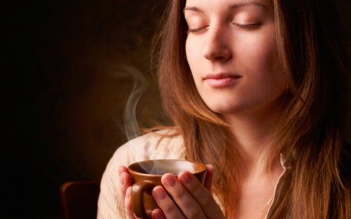 Kvinne som lukter på kaffe