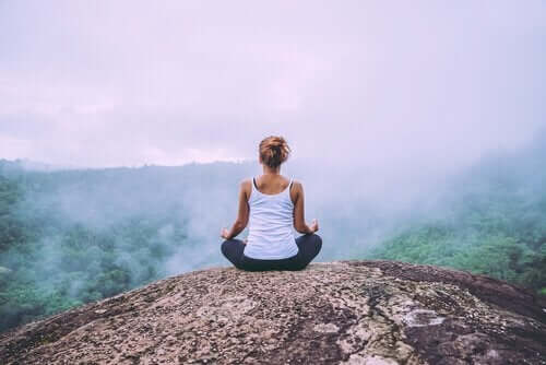 Kvinne mediterer i naturen