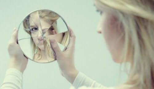 En kvinne som ser på seg selv i et ødelagt speil.