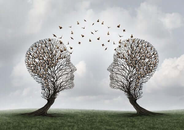 Bildet av to trær som ser ut som hoder med fugler som flyr mellom dem