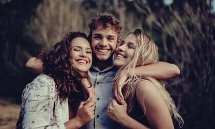 Tre venner som klemmer.