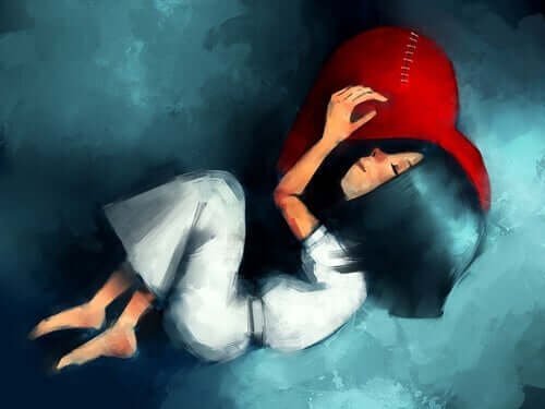 En jente sover med hodet på en rød pute formet som et hjerte
