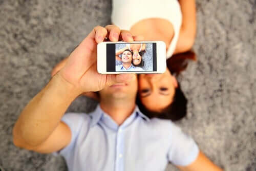 En mann som tar en selfie av seg selv og en kvinne.