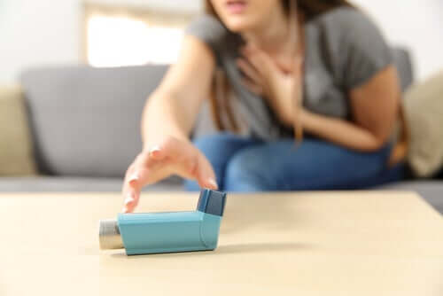 En kvinne som strekker seg etter inhalatoren sin