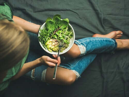 En kvinne som spiser salat
