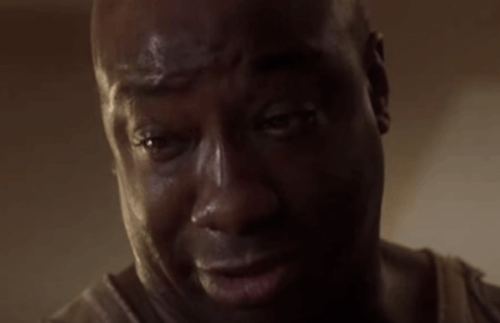 John Coffey i Den grønne mil ser ned, med tårer i øynene.
