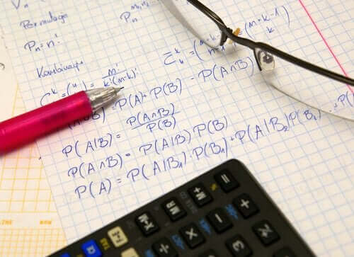 En sannsynlighetseksamen med en kalkulator, en penn og et par briller.
