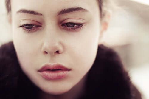 En kvinne med triste øyne som opplever et sår som ikke gir arr.