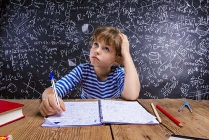 En liten gutt som studerer matematikk.