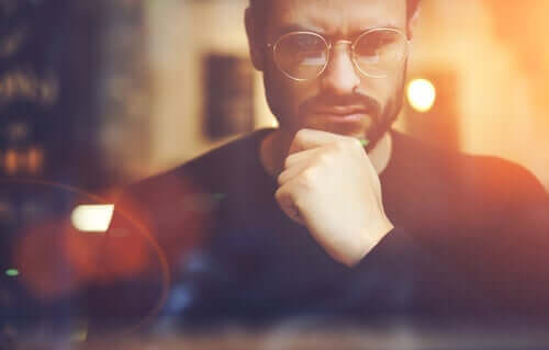 En mann med briller muligens engasjert i dyp kontrafaktuell tenking.