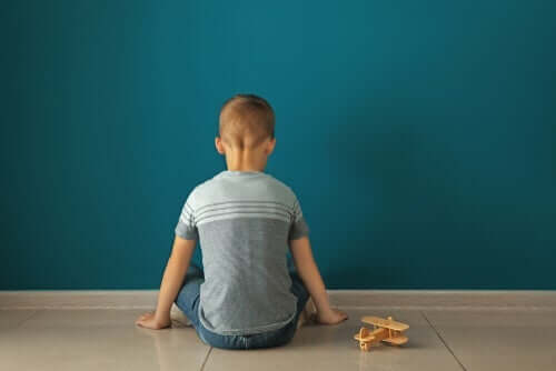 Et barn som sitter foran en vegg med et leketøyfly.