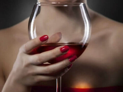 Kvinne som holder et glass vin.