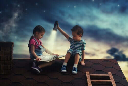 To barn som leser en bok på et hustak