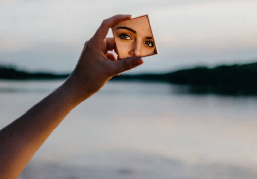 En kvinne som ser på seg selv i et lite speil