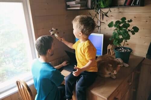 En far som arbeider og et barn med et leketøy