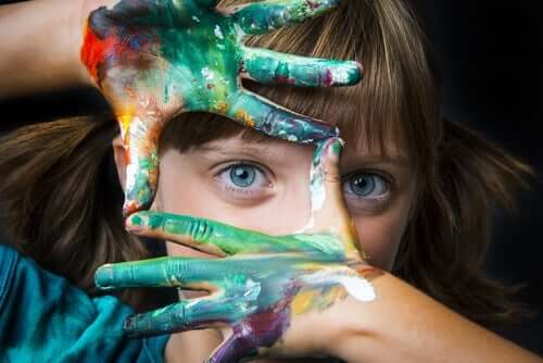 En jente med maling på hendene sine