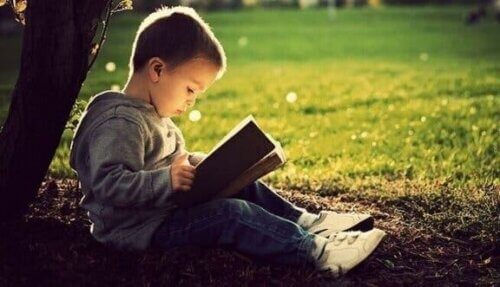En liten gutt som leser en bok.