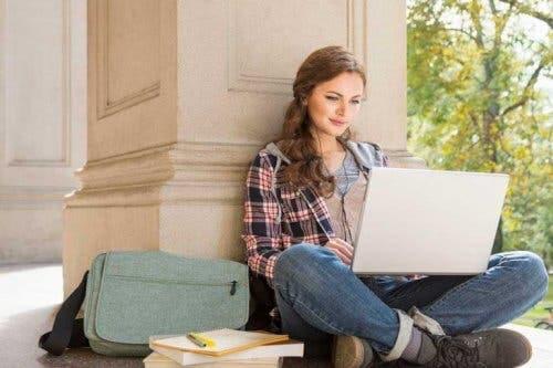 En jente som sitter med en laptop