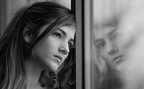 En kvinne som ser ut av vinduet.