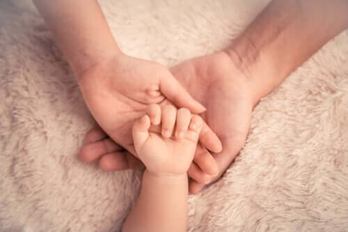 En babyhånd i voksnes hender