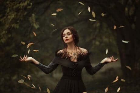 En kvinne med åpne armer lager en sirkel av blader.