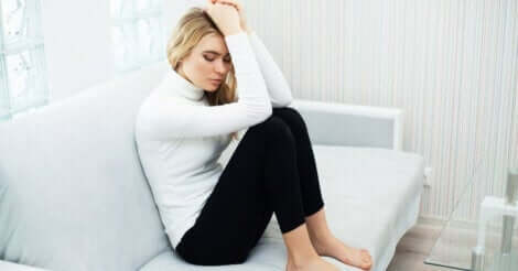 En kvinne med angst på sofaen.