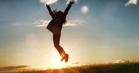 En kvinne som hopper foran solen.