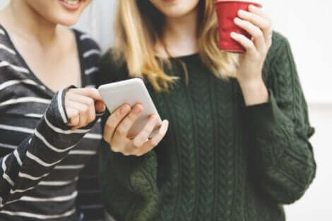 To jenter som ser på en mobiltelefon
