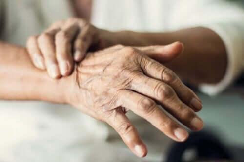 En gammel kvinne som lider av skjelvende hender.