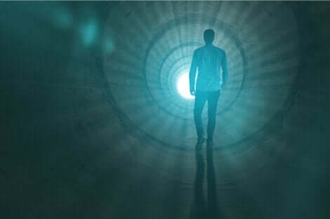 En mann som går mot lyset i enden av tunnelen.