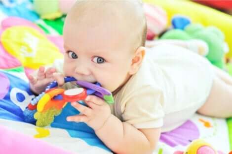 En baby som leker og jobber med sensorisk utvikling.