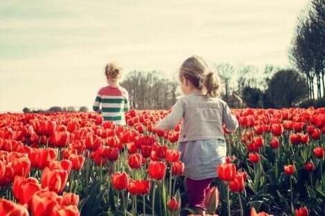 To barn som går gjennom en eng av tulipaner og lærer sosioemosjonelle ferdigheter.