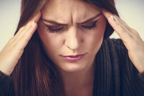 En kvinne med hodepine som lider av søvnforstyrrelser.