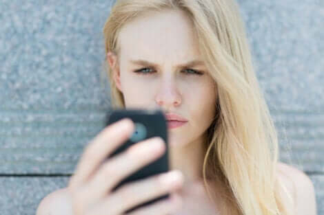 En kvinne som ser på mobiltelefonen sin.