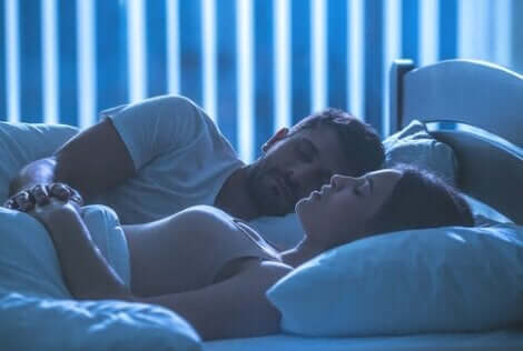 En mann og en kvinne som ligger i sengen.