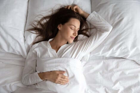 En kvinne som sover godt i sengen.
