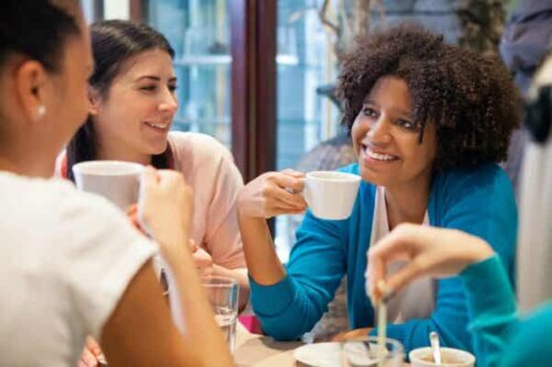 En gruppe kvinner som snakker over kaffe.