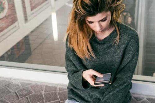 En kvinne som ser på telefonen sin.