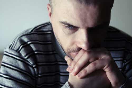 En mann som føler seg bekymret og lei seg mens han tenker på hvordan hans oppvekst påvirker voksne forhold.